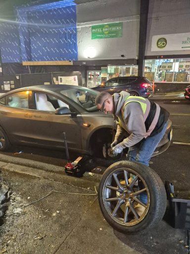 roadside tire repair in jersey city Happy road services Roadside assistance in Jersey City NJ fixing flat tire and helping Tesla driver