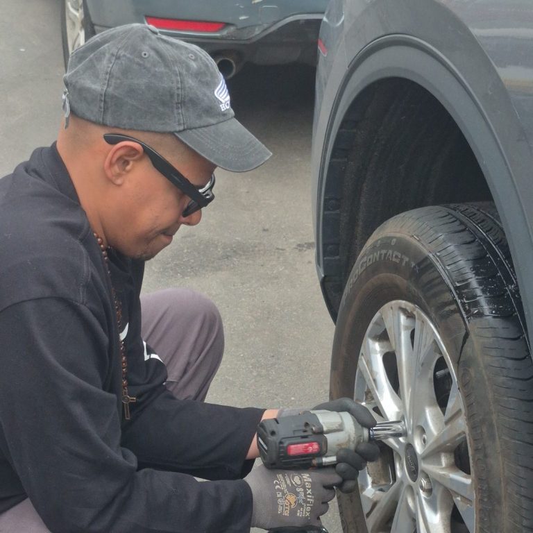 Ford Flat Tire Change Bayonne NJ — Mobile Tire Repair | Happy Road Services Happy Road Services changing a flat tire on a Ford in Bayonne NJ — mobile tire repair and roadside assistance