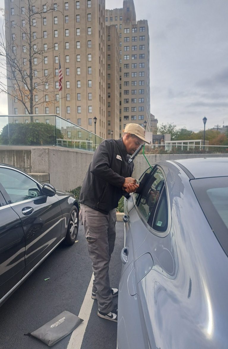 car unlocking in Jersey City NJ Happy road services tech doing a car unlocking in Jersey City NJ