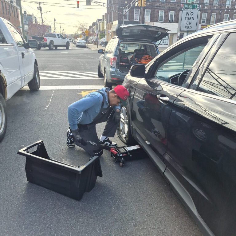 Flat Tire Change & Roadside Tire Repair — Bayonne NJ | Happy Road Services Happy Road Services technician performing flat tire change and roadside tire repair in Bayonne NJ